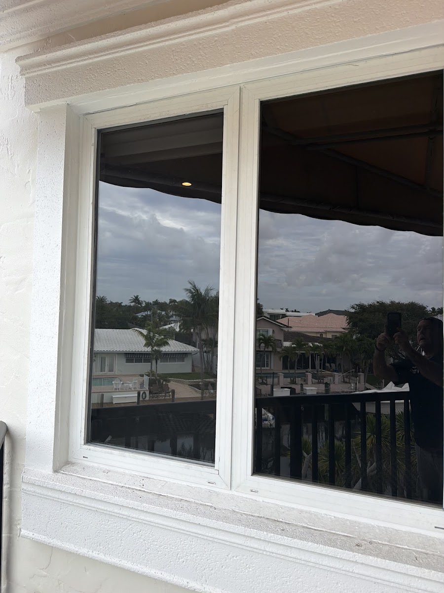 Glass technician carrying a replacement pane on a Boca Raton job site
